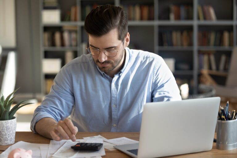 Professional using a calculator and laptop