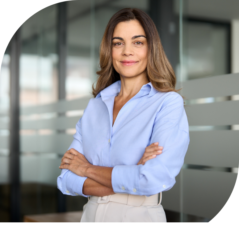 Eine Frau verschränkt die Arme und lächelt und schaut direkt in die Kamera