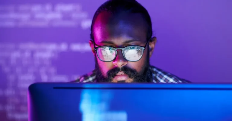 man looking at monitor wearing glasses